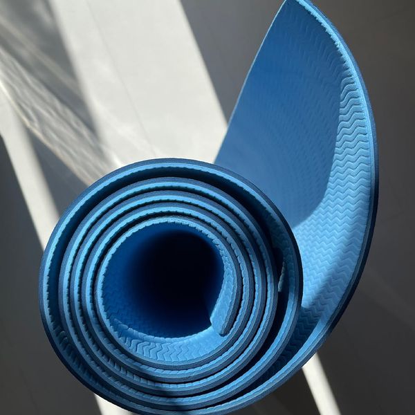 A rolled yoga mat in a bright room
